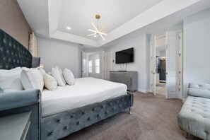 A bedroom with a bed, a television, a dresser, and a closet. - Beautiful &Relaxing 5BR Home w/Private Pool (62EW) (Kissimmee)