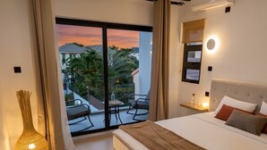 Een slaapkamer met een bed, nachtkastje, lamp en uitzicht.