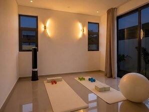 A modern room with exercise equipment, large windows, and a view of the outdoors. - Villa Moony | Private Pool, Rooftop, and Wellness Villa in Mauritius (Trou aux Biches)