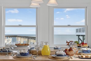 Une table dressée pour un repas, avec vue sur la mer et un quai.