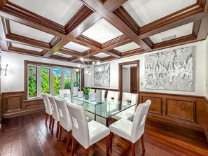 A spacious dining area with a glass table, white chairs, and a view of greenery through large windows. - Heated Pool & Hot Tub! Pool Table+Close To Beach! (Fort Lauderdale)