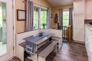 A kitchen with a bench, a dining table, and a view of the outdoors.