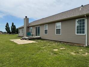 A single-story house with a covered patio, a chimney, and a lawn.