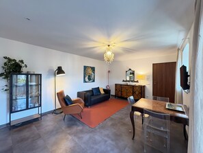 A living room with a sofa, armchair, dining table, and a chandelier. - "C7 Balcony Railing" — New, with a balcony in Omegna (Omegna)
