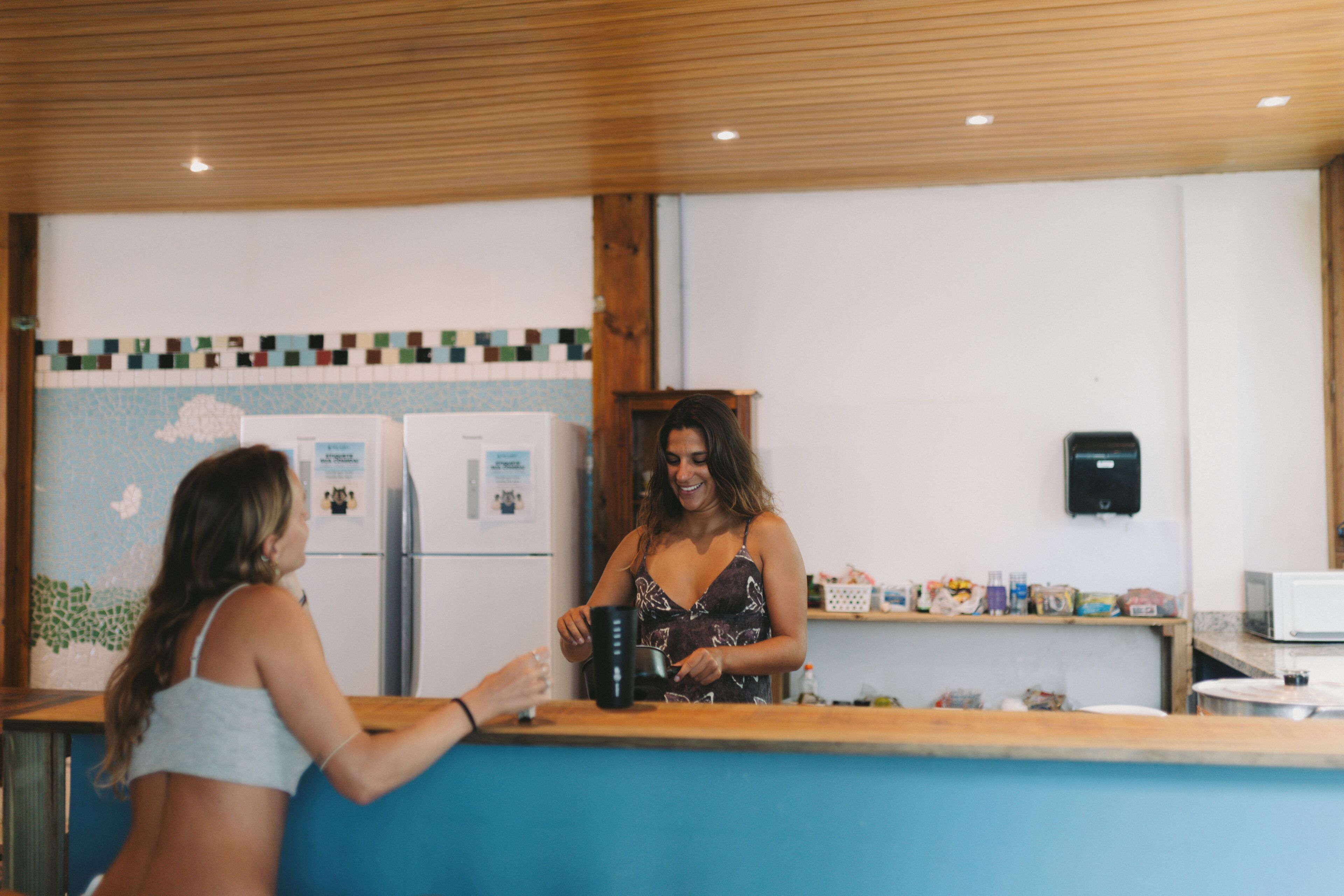 A bar area with a counter, a refrigerator, and a microwave.