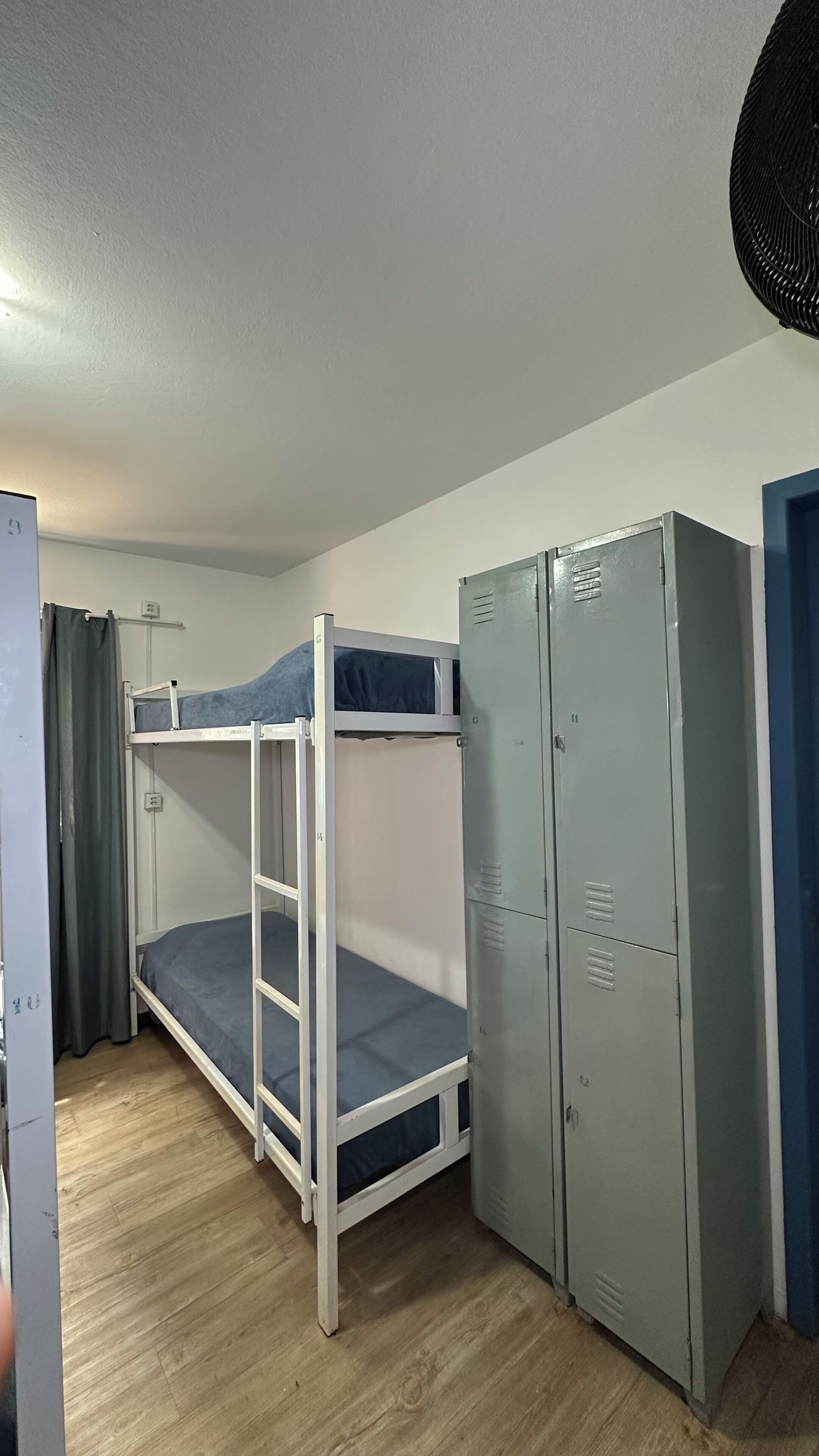 A bunk bed with a storage cabinet and a door.