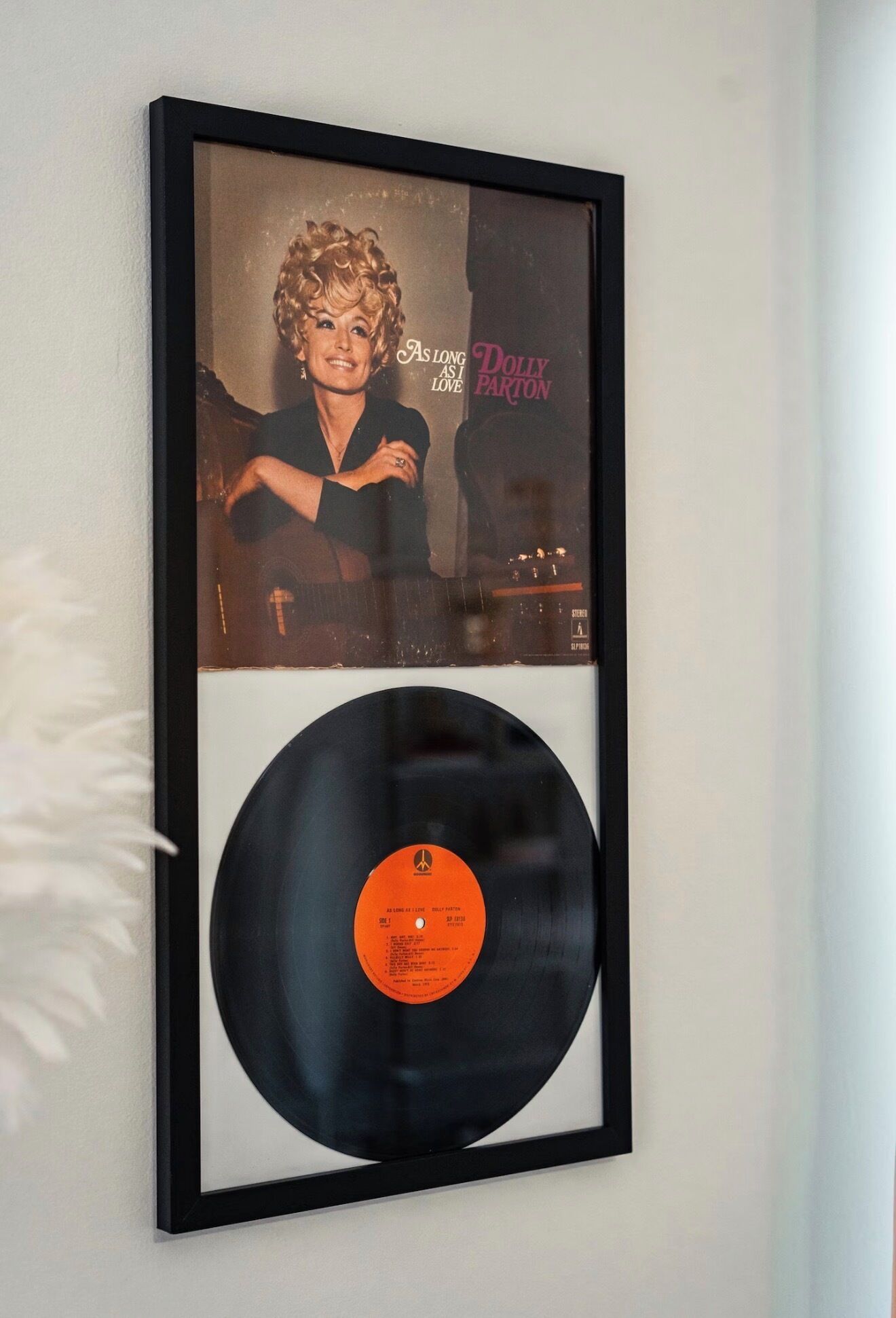 A framed photograph of a person with a vinyl record below it.