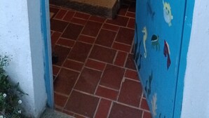 Ein Badezimmer mit blauen und weißen Fliesen, einer Duschkabine und einer Tür mit maritimen Tierbildern.
