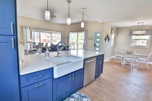 A kitchen with blue cabinets, a white countertop, and a dishwasher. - 167 Mandalay Rd - "Diamond Cottage" (Fort Myers Beach)