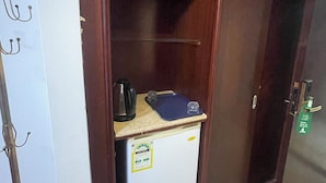A wardrobe with a small refrigerator, a kettle, and a blue tray on top. - Rimas Al Anoud Hotel (Makkah)