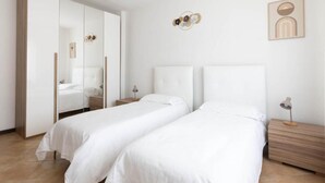 A bedroom with two beds, a wardrobe, a nightstand, and wall art. - Locanda Antica Bribano (Sedico)