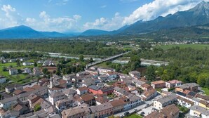 A town with a prominent church, a river, and mountains in the background. - Locanda Antica Bribano (Sedico)