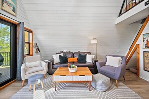 Uma sala de estar acolhedora com um sofá, poltronas e uma mesa de centro.