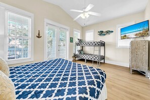 A bedroom with a bunk bed, a ceiling fan, a TV, and large windows. - Destin Beach Vibes, sleeps 13, 2min walk to private beach, heated community pool (Destin)