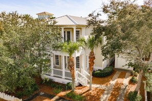 A two-story house with a porch, a staircase, and a well-maintained garden. - Destin Beach Vibes, sleeps 13, 2min walk to private beach, heated community pool (Destin)