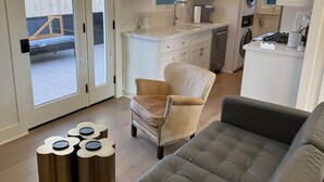Ein modernes Wohnzimmer mit einem grauen Sofa, einem beigefarbenen Sessel und einem kleinen Tisch mit Dekoration.