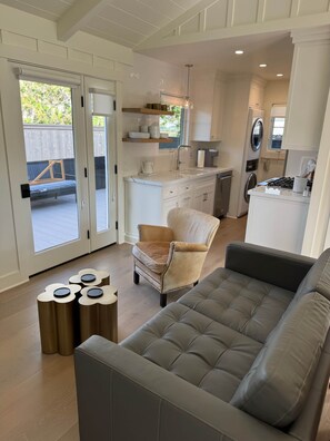 Ein modernes Wohnzimmer mit einem grauen Sofa, einem beigefarbenen Sessel und einem kleinen Tisch mit Dekoration.