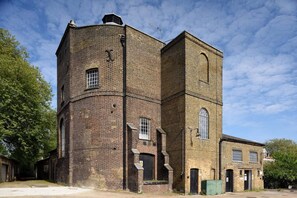 A brick building with a tower, multiple windows, and a door. - Chic Arlington Home | Walk to Angel & King’s Cross (Greater London)