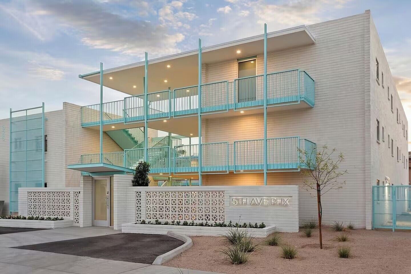 A multi-story building with a balcony, a staircase, and a sign reading '5TH AVE PHX'.