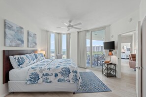 A bedroom with a bed, ceiling fan, artwork, and a view of the outside. - 2815 Gorgeous Gulf Views ~ Pools ~ Bar ~ Gym ~ Pickleball & More ~ Book Oct 26th (Destin)