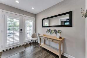 Un interior modern amb una taula de consola de fusta, un mirall i plats decoratius a la paret.