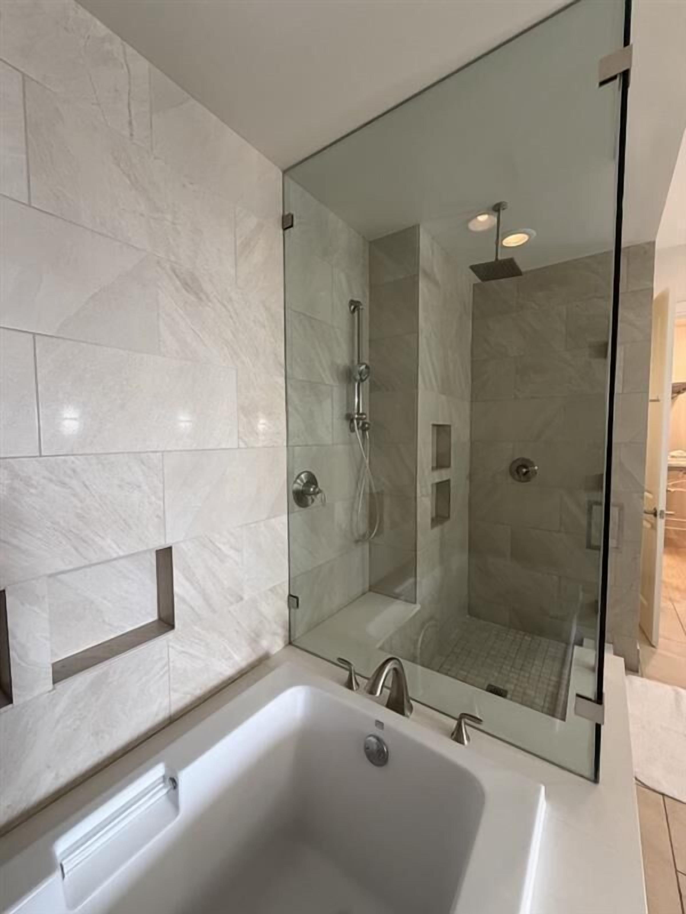 Ein modernes Badezimmer mit großem Spiegel, einer Badewanne und einer Duschkabine.