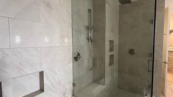 Ein modernes Badezimmer mit großem Spiegel, einer Badewanne und einer Duschkabine.