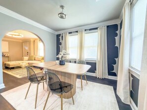A dining area with a wooden table, chairs, and a vase of flowers. - Stay Near Downtown Atlanta & Airport (Atlanta)