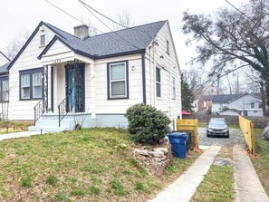 A single-story house with a front porch, a small front yard, and a driveway leading to a parked car. - Stay Near Downtown Atlanta & Airport (Atlanta)