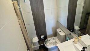 Une salle de bain moderne équipée de toilettes, d’un bidet et d’un lavabo.