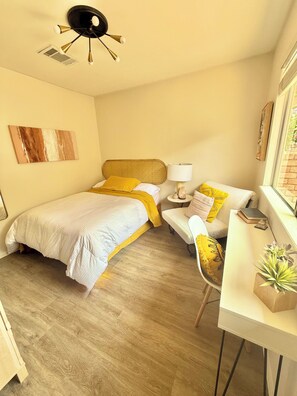 A bedroom with a bed, bedside table, chair, and a desk with a lamp. - South Austin Sanctuary Location! Greenbelt, trifold, vaulted, pool, garage, pets (Austin)