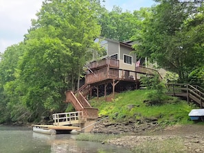 Ein Haus mit einer Terrasse und einer Treppe zu einem Steg über einem Fluss.