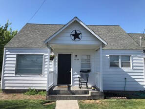 A single-story house with a black door, a star decoration above the entrance, and the number 1525 on the door.