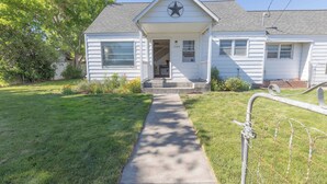 A single-story house with a front porch, a star decoration above the door, and a number '1525' on the wall.