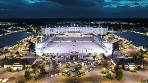 Um estádio amplo e bem iluminado, com vários níveis de arquibancada e um campo central.