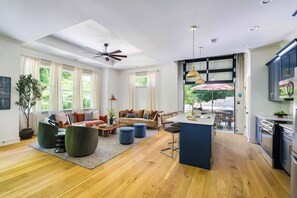 Ein geräumiger Wohnbereich mit einer Couch, Hocker und einem Essbereich mit einer Bar.