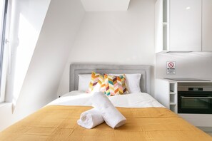 Hotelkamer met een bed, een 'NO NOISE' bord, een magnetron en een raam.