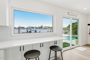 A modern kitchen with a large window overlooking a marina and pool. - Bay Oasis Intercoastal Pool Home w/Hot Tub (Indian Rocks Beach)