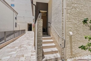 A narrow alleyway with a staircase leading to a building entrance. - 21 Sea Club Condo Near Beach (Indian Shores)