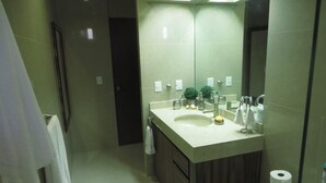 A modern bathroom with a large mirror, a sink, and a toilet. - Luxury Apartment 40 m from the Beach and Bike Path (Mazatlán)