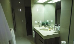 A modern bathroom with a large mirror, a sink, and a toilet. - Luxury Apartment 40 m from the Beach and Bike Path (Mazatlán)