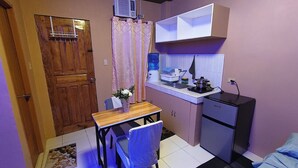 Una cocina compacta con refrigerador, lavamanos y estufa.