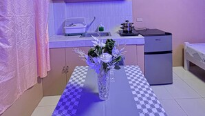 Una cocina compacta con refrigerador, pileta y encimera.