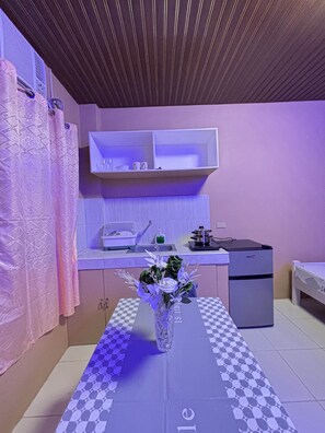 Eine kleine Küche mit Kühlschrank, Spüle und Arbeitsplatte.