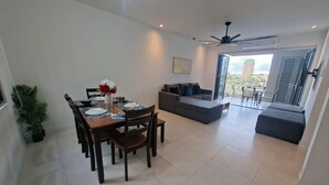 Ein modernes Wohnzimmer mit Essbereich, einer Sofagarnitur und einem Balkon mit Blick.
