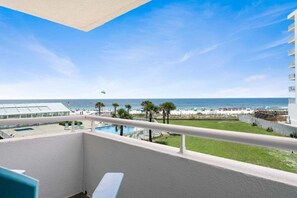Ein Balkon mit Blick auf Strand, Pool und das Hotelgebäude.