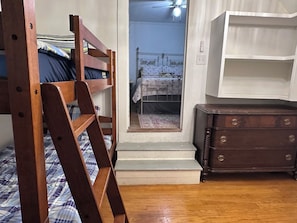 A bedroom with a wooden ladder, a dresser, and a bed with striped bedding. - Entire House in Cambridge (Cambridge)