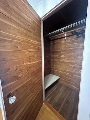 A small, wooden-paneled closet with a metal rod for hanging items. - Entire House in Cambridge (Cambridge)
