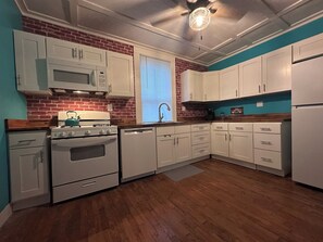A kitchen with white cabinets, a stove, and a dishwasher. - Entire House in Cambridge (Cambridge)