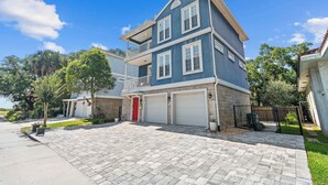 A two-story house with a garage, a red door, and a balcony. - Blue Heron on May Vacation Rental (St. Augustine)